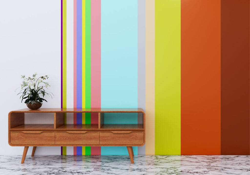 A coffee table with a plant in front of a wall with different colored strips of paint.